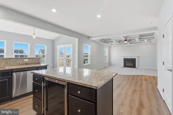 a kitchen with granite countertop kitchen island a sink stove and refrigerator