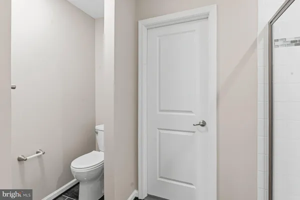 a white toilet sitting next to a shower