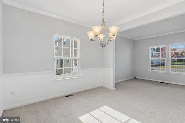 a view of a livingroom with a chandelier fan and windows