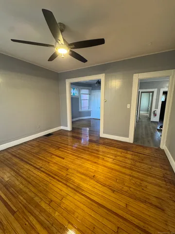a view of empty room with wooden floor