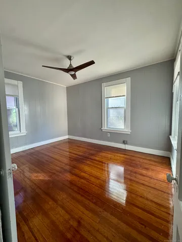 a view of a livingroom with wooden floor and a ceiling fan