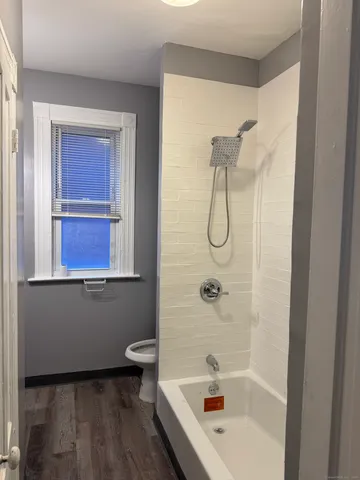 a bathroom with a granite countertop sink a toilet and shower