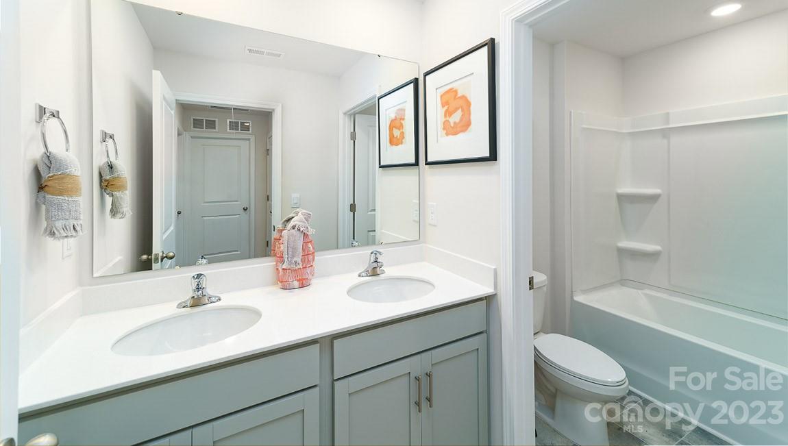 4115 Village Boulevard Northwest Conover, NC 28613 - Photo 17 of 22 a bathroom with a granite countertop toilet sink and mirror