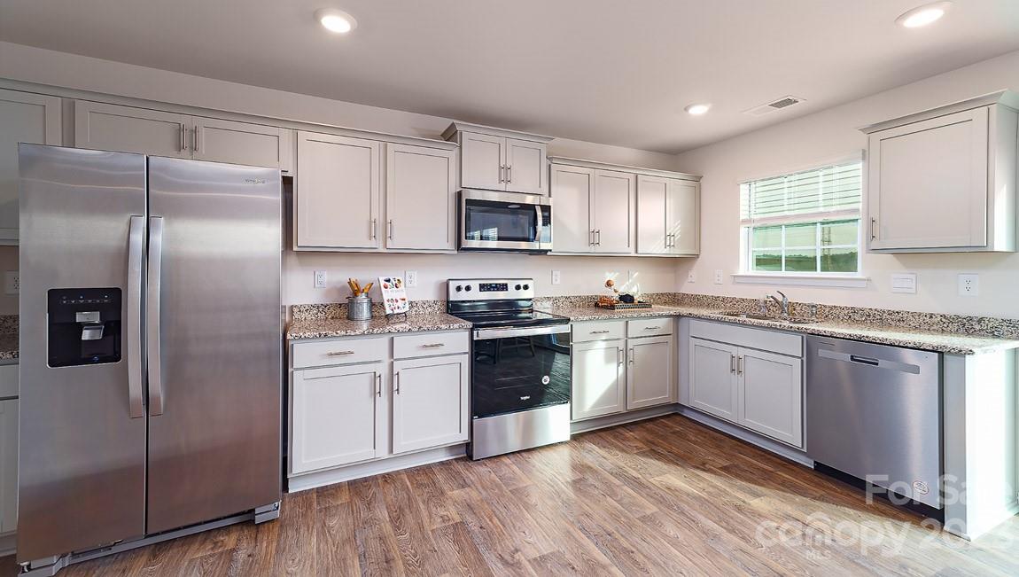 4115 Village Boulevard Northwest Conover, NC 28613 - Photo 6 of 22 a kitchen with granite countertop a refrigerator sink and microwave