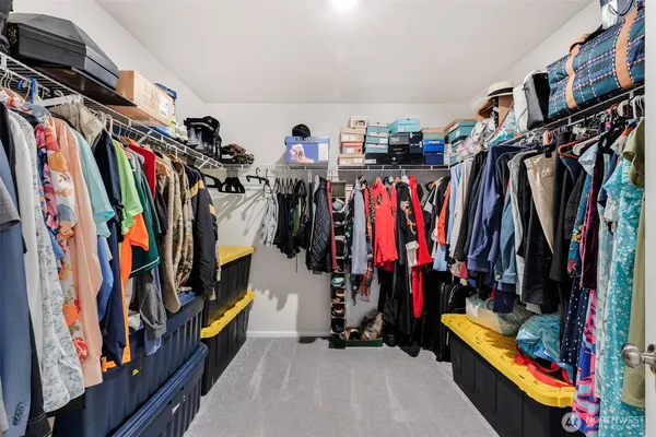 a view of walk in closet with clothes