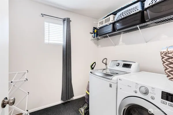 a view of washer and dryer with kitchen in the background