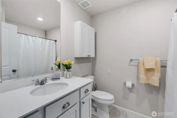 a bathroom with a granite countertop sink toilet and a mirror