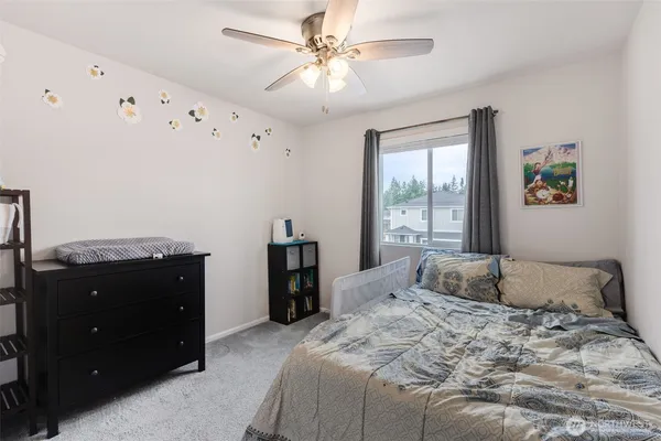 a bedroom with a bed window and dresser