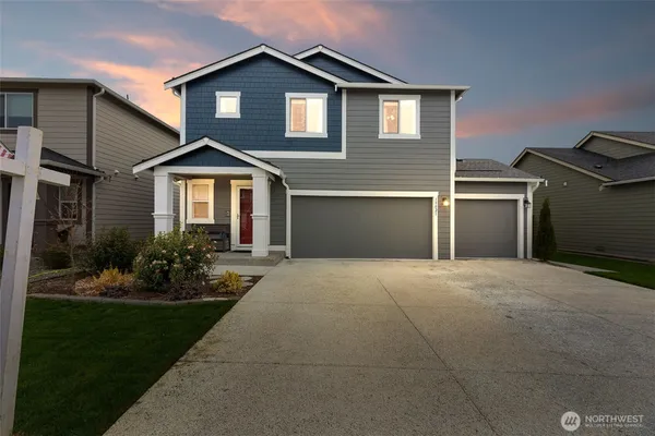 a front view of a house with a yard and garage