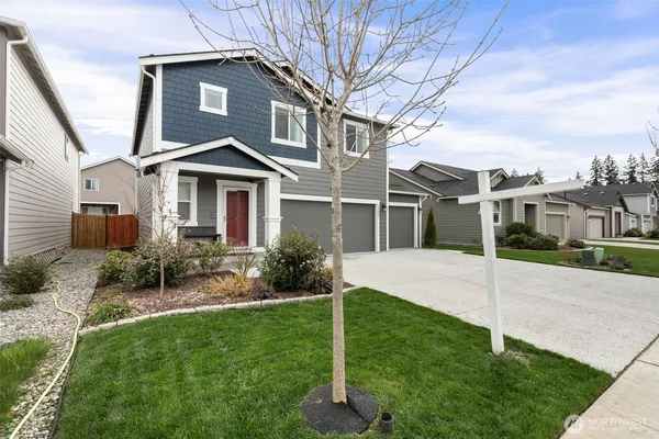 a view of a white house with a yard and plants