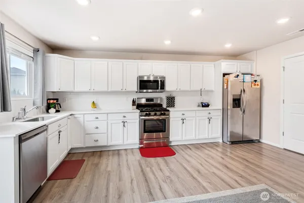 a kitchen with a refrigerator and a stove top oven