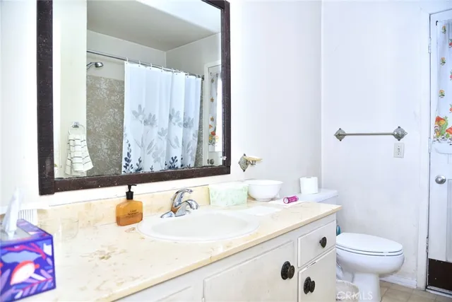 a bathroom with a granite countertop sink mirror vanity and toilet