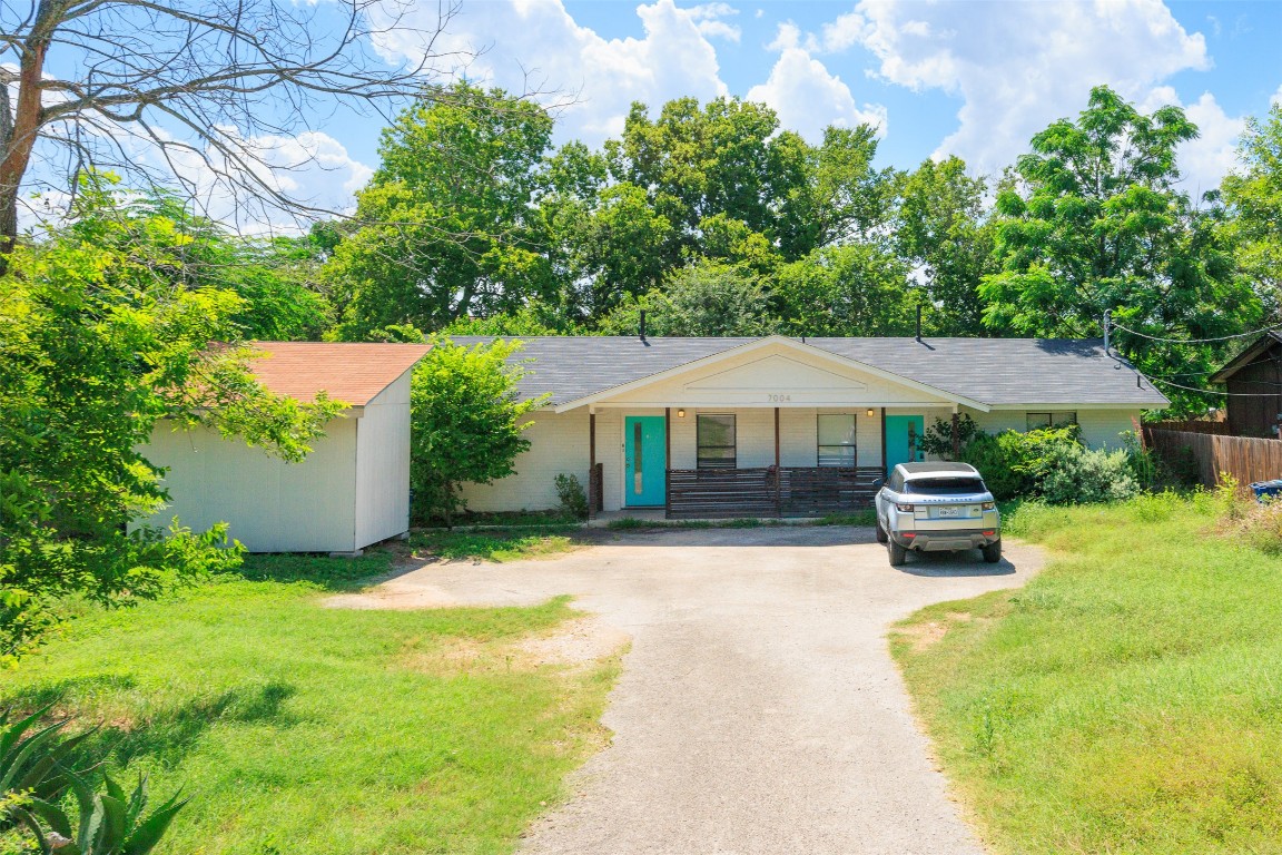 a front view of a house with yard and trees
