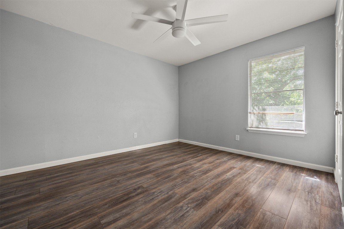 7004 Circle S Road, Unit A Austin, TX 78745 - Photo 12 of 16 an empty room with wooden floor fan and windows