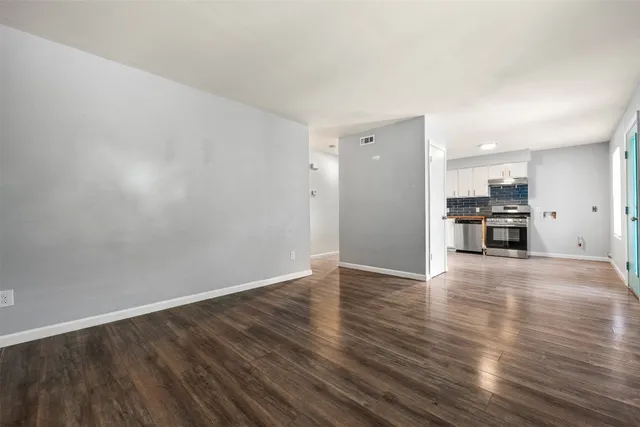 a view of empty room with wooden floor