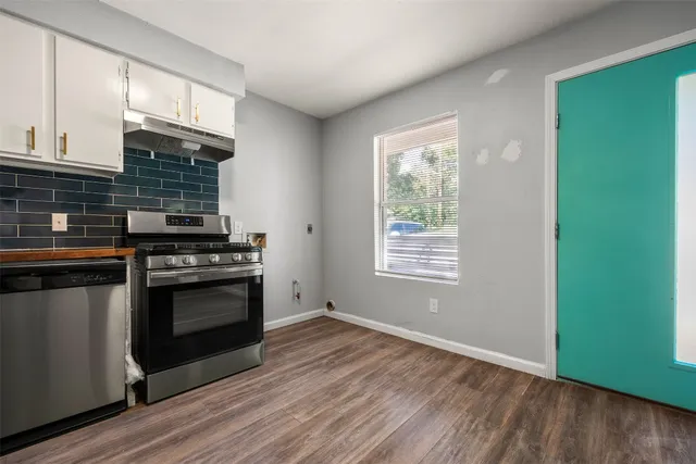 a kitchen with granite countertop stainless steel appliances a stove top oven and sink