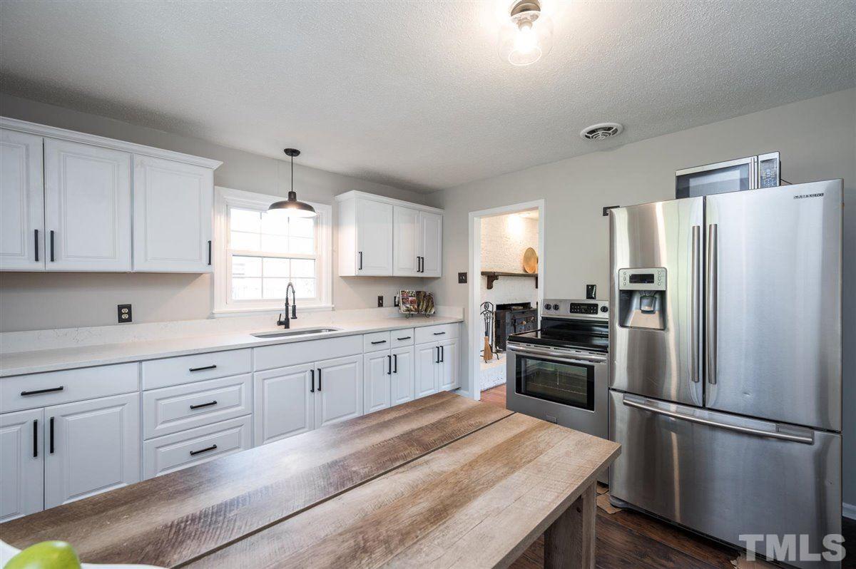 3814 Woodside Road Garner, NC 27529 - Photo 14 of 28 a large kitchen with white cabinets and stainless steel appliances