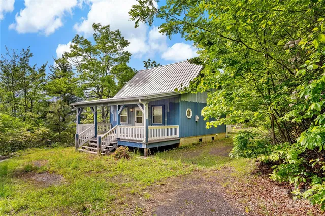 a view of a house with a yard and sitting area