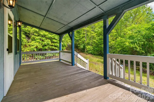 a view of a porch with wooden floor and iron stairs