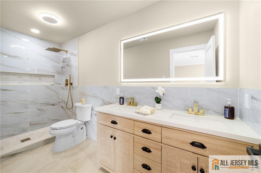 747 Marlton Road, Unit 747A Monroe Township, NJ 08831 - Photo 21 of 30 a bathroom with a double vanity sink toilet mirror and shower