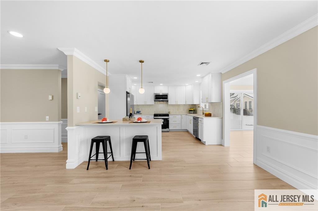 747 Marlton Road, Unit 747A Monroe Township, NJ 08831 - Photo 6 of 30 a large white kitchen with a table and chairs