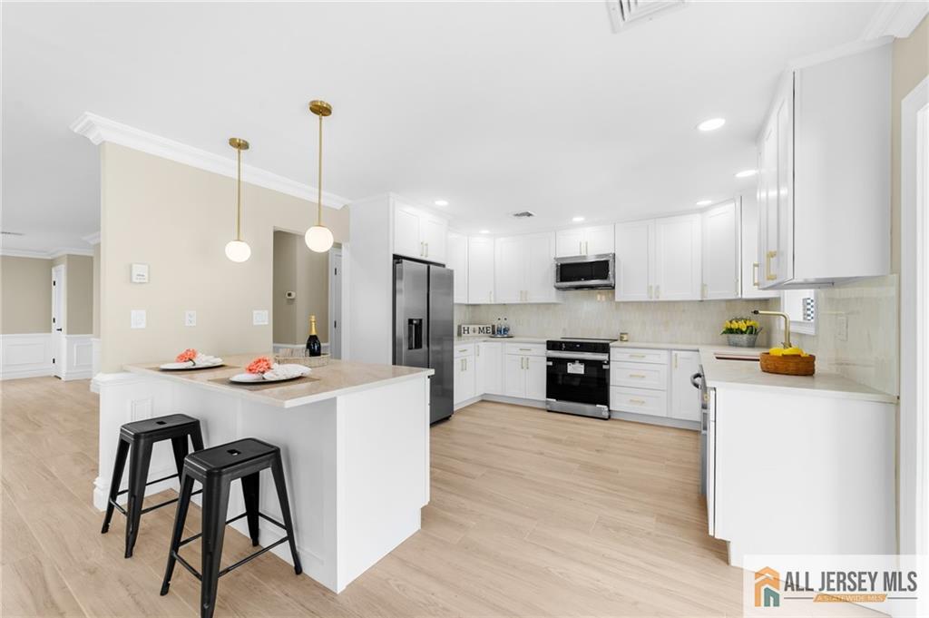 747 Marlton Road, Unit 747A Monroe Township, NJ 08831 - Photo 7 of 30 a open kitchen with stainless steel appliances kitchen island a stove a sink a refrigerator a center island and cabinets