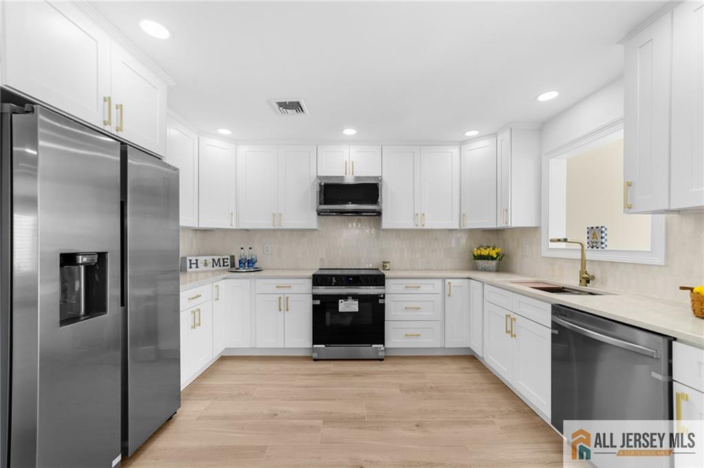 747 Marlton Road, Unit 747A Monroe Township, NJ 08831 - Photo 8 of 30 a kitchen with stainless steel appliances granite countertop a refrigerator a stove a sink and a microwave