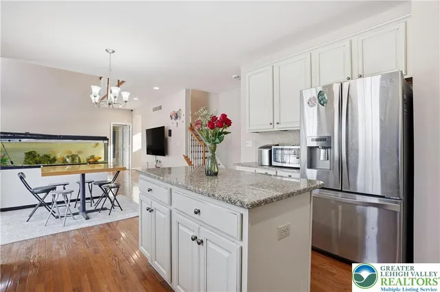 a kitchen with stainless steel appliances granite countertop a refrigerator and a stove top oven