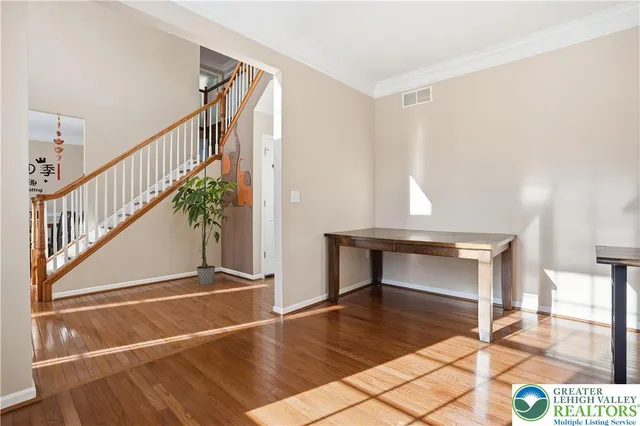 a view of entryway and hall with wooden floor