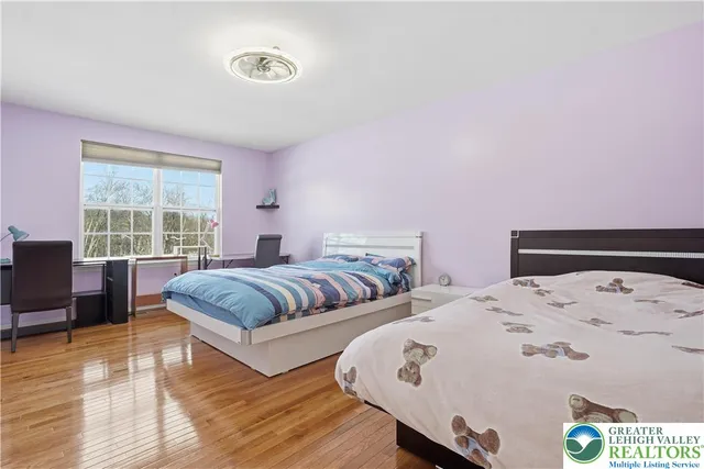 a bedroom with two beds and a large window