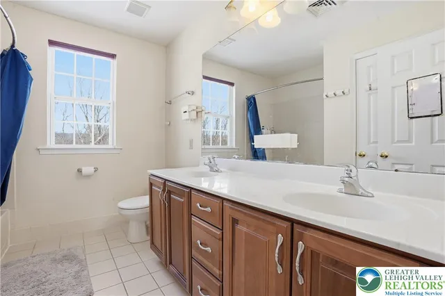 a bathroom with a granite countertop sink a toilet and a mirror