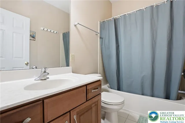 a bathroom with a sink a toilet a mirror and shower curtain