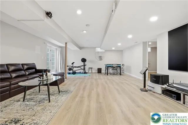 a living room with furniture a flat screen tv and a table