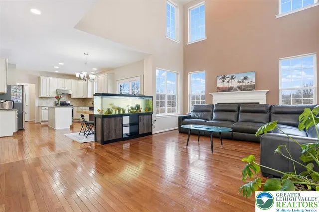 a living room with stainless steel appliances furniture and a kitchen view