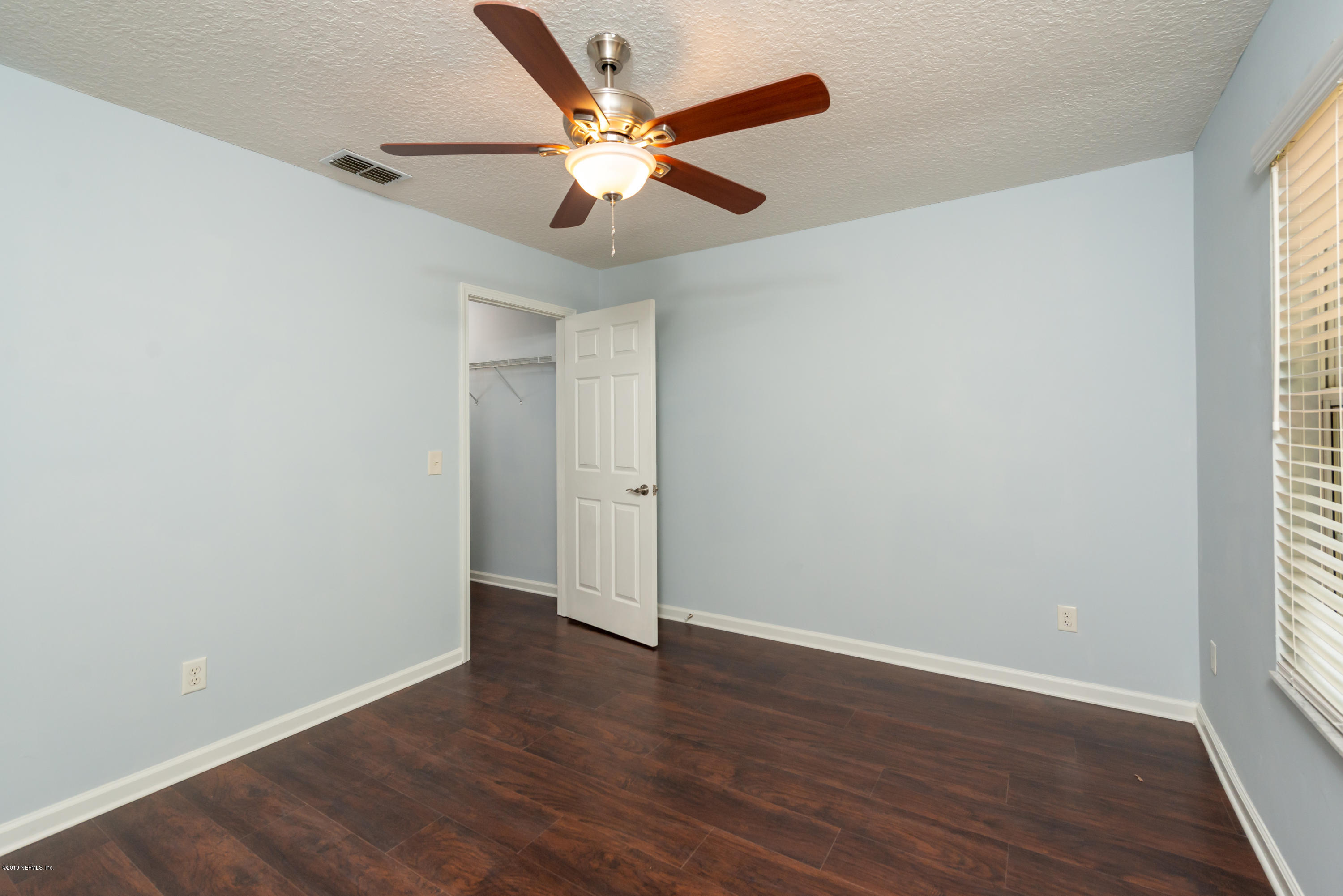 107 Mohegan Road St. Augustine, FL 32086 - Photo 21 of 38 an empty room with wooden floor ceiling fan and windows