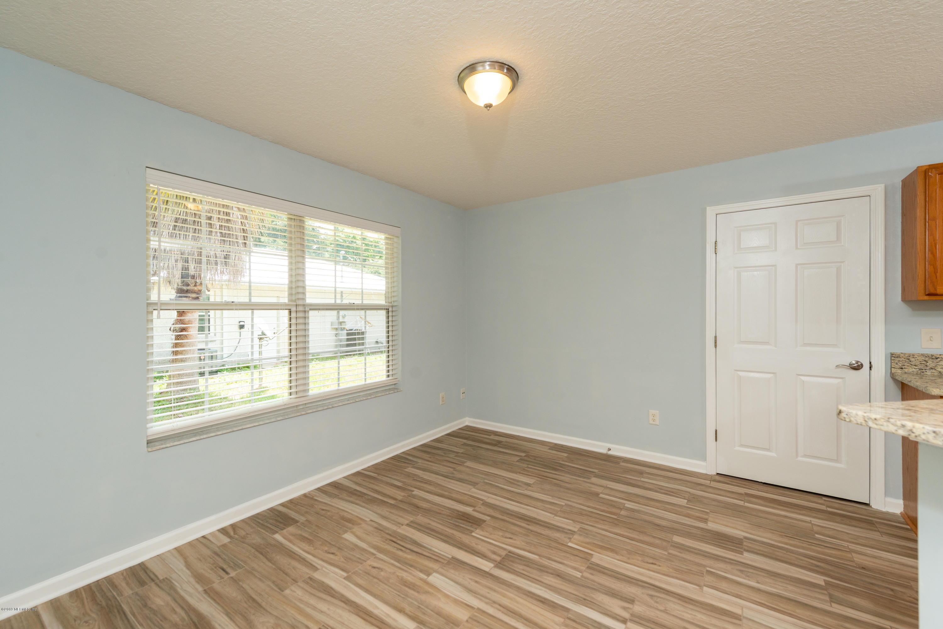 107 Mohegan Road St. Augustine, FL 32086 - Photo 8 of 38 a view of an empty room with wooden floor and a window