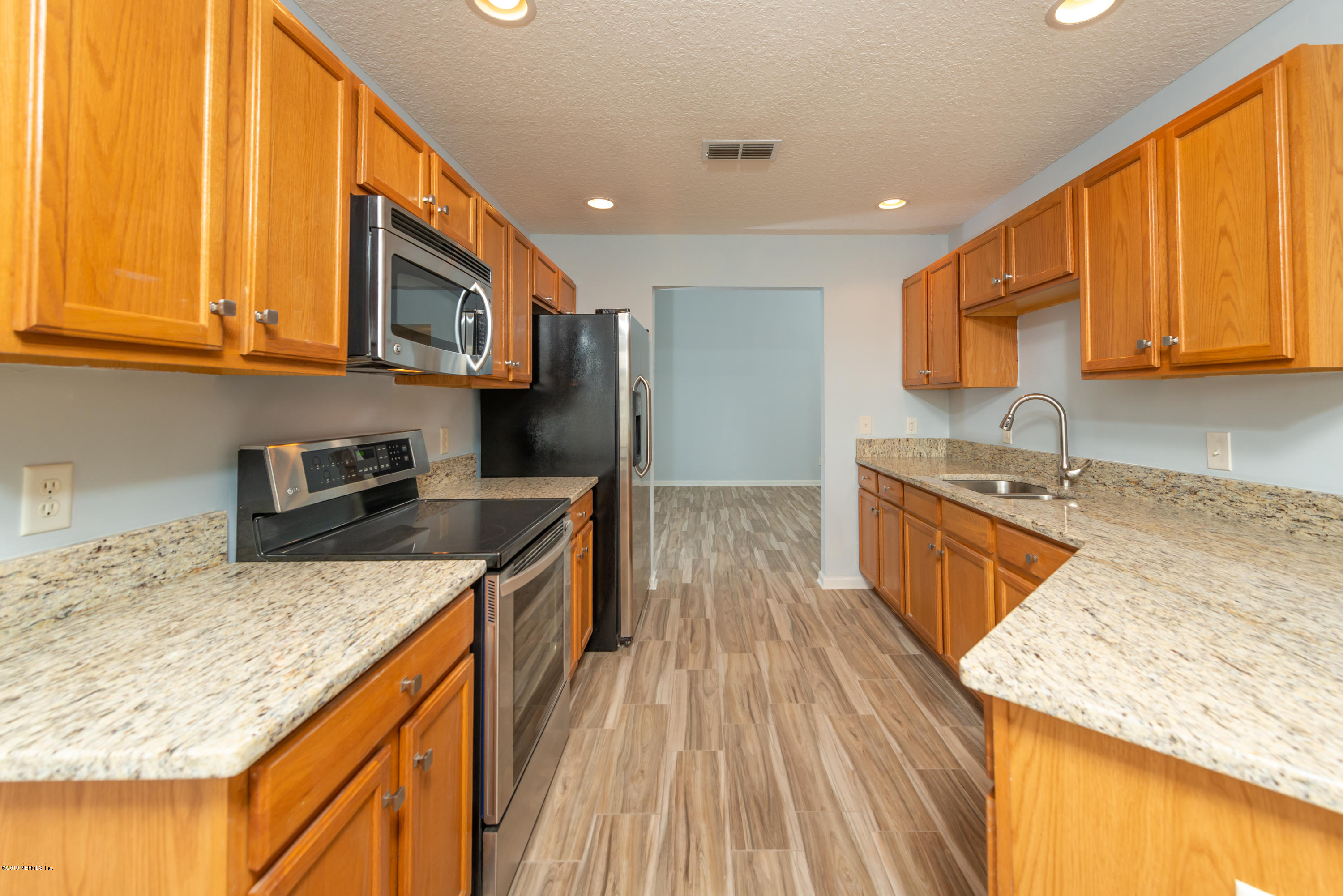 107 Mohegan Road St. Augustine, FL 32086 - Photo 9 of 38 a kitchen with stainless steel appliances granite countertop wooden cabinets and a stove top oven