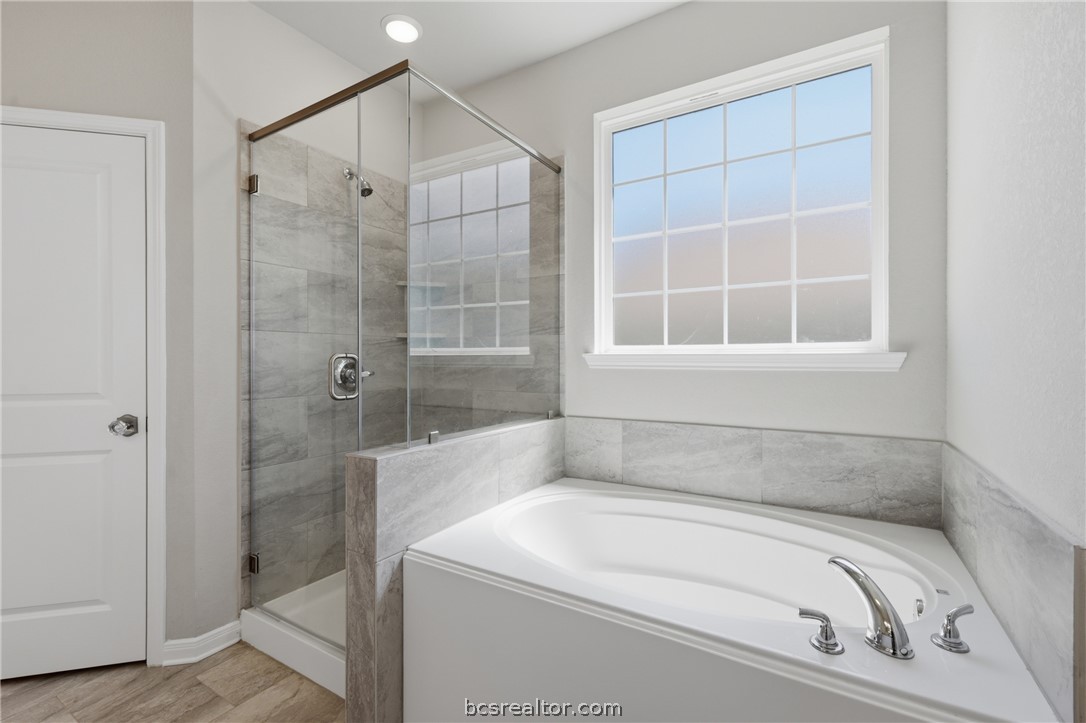 1922 Viva Road Bryan, TX 77807 - Photo 19 of 45 Well-appointed primary bathroom offers granite countertops, dual vanities, a soaking tub, and walk-in shower.