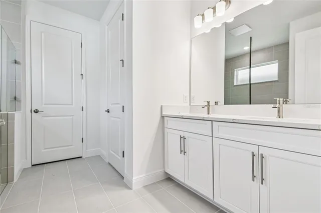 a bathroom with double sink and a mirror