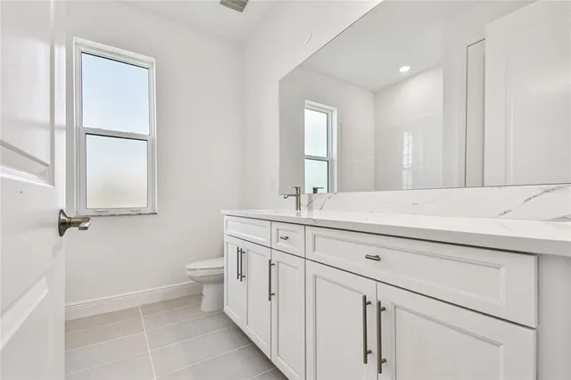 a bathroom with a double vanity sink a toilet and a mirror