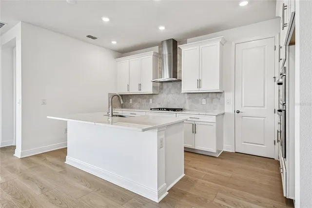 a kitchen with cabinets appliances a sink and a counter top space