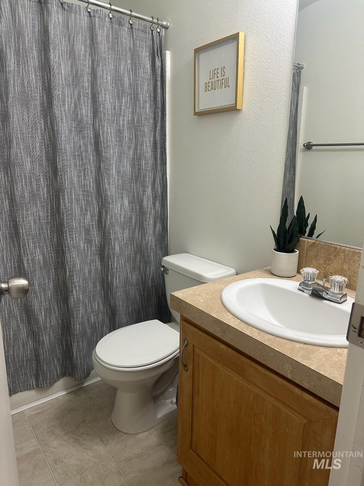 1171 North Sable Lane Boise, ID 83704 - Photo 6 of 19 Bathroom with vanity, curtained shower, a textured wall, and light tile patterned flooring