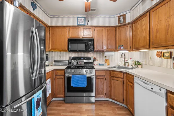 a kitchen with stainless steel appliances granite countertop a refrigerator stove a sink and dishwasher