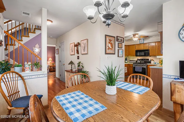 a view of a dining room with furniture a chandelier and wooden floor