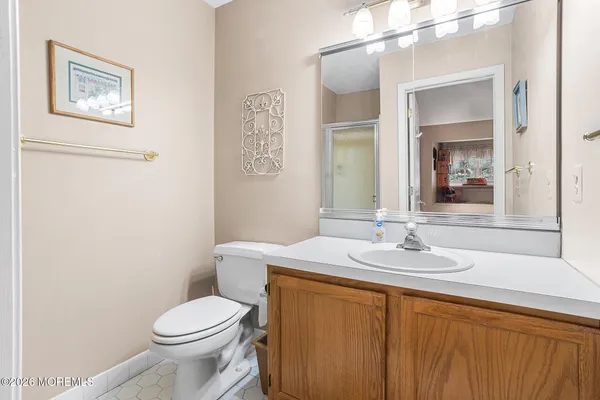 a bathroom with a toilet a sink and mirror