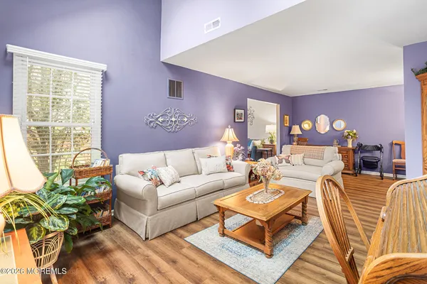 a living room with furniture a lamp and a potted plant