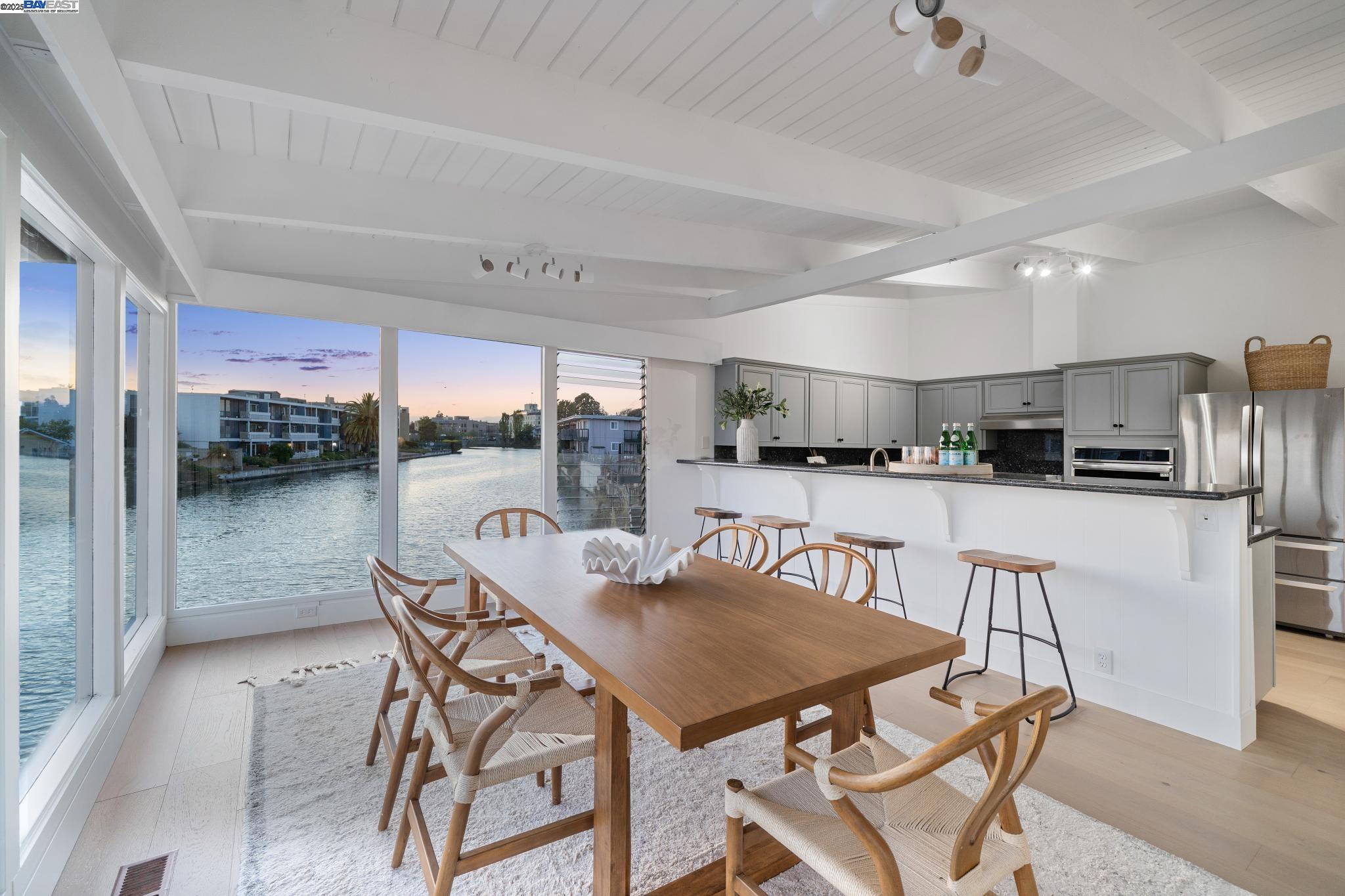 a view of a dining room with furniture and a kitchen view