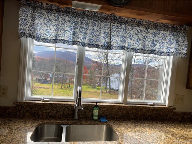 a bathroom with a sink a bathtub and next to a window
