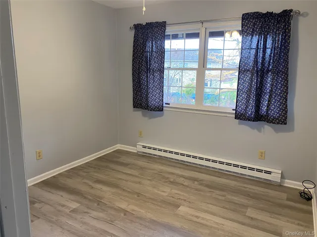 a view of a room with a window and wooden floor