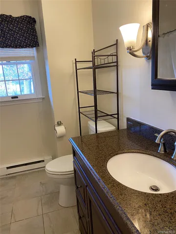 a bathroom with a sink a toilet and mirror